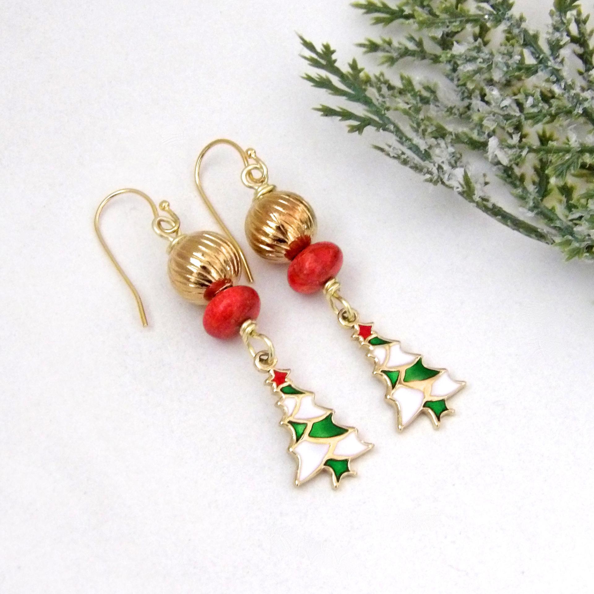 Full of whimsical holiday charm, these handmade dangle earrings feature small 14K gold plated Christmas tree charms with a colorful enameled finish. They are accented with red coral and textured gold brass beads. Perfect for the holiday and Christmas season, they'll make a great gift for women of all ages. Earrings are lightweight and comfortable to wear. 