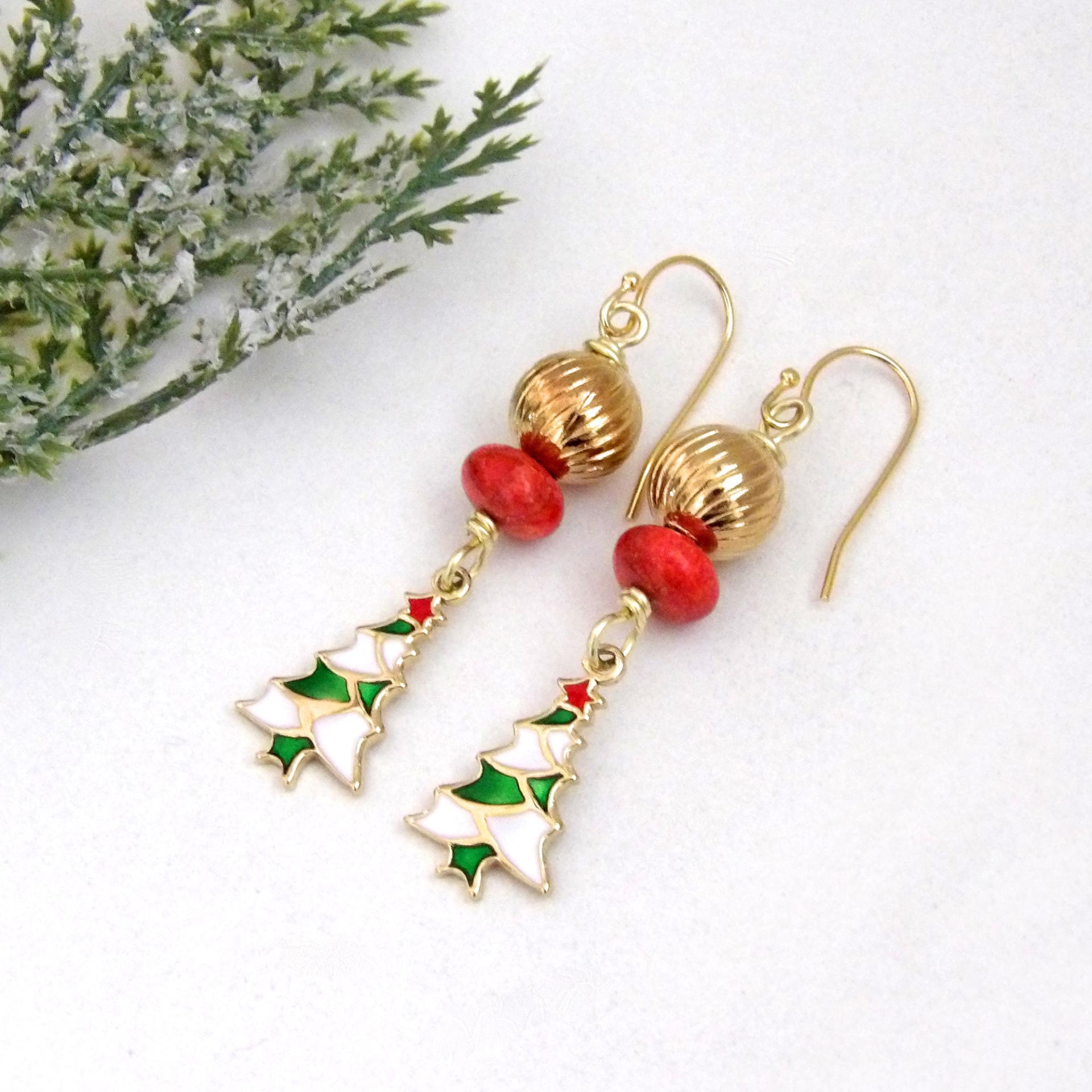 Full of whimsical holiday charm, these handmade dangle earrings feature small 14K gold plated Christmas tree charms with a colorful enameled finish. They are accented with red coral and textured gold brass beads. Perfect for the holiday and Christmas season, they'll make a great gift for women of all ages. Earrings are lightweight and comfortable to wear. 