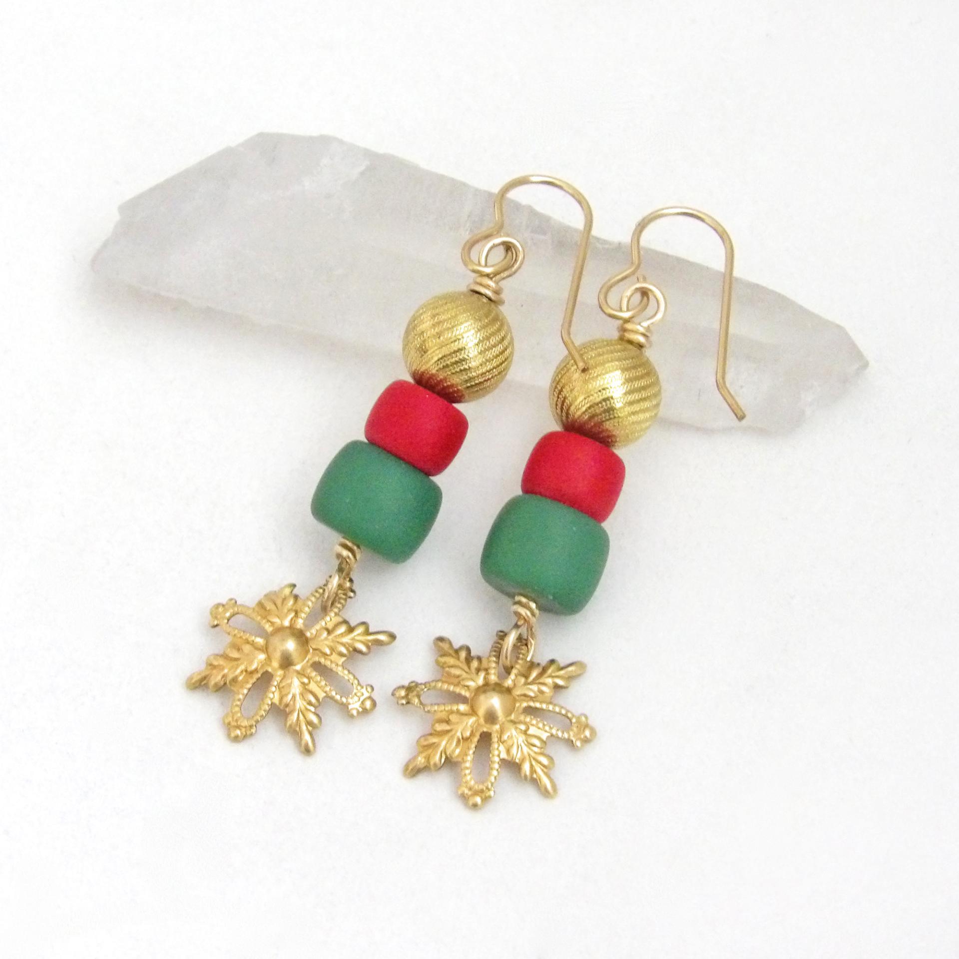 Full of elegant holiday charm, these handmade dangle earrings feature gold brass snowflake filigree charms accented with red and green glass beads topped off with textured gold brass beads. They have a modern charm with a boho chic style that's perfect for the holiday and Christmas season. They'll make a great gift for someone that loves handmade jewelry - or a nice addition to your own wardrobe.