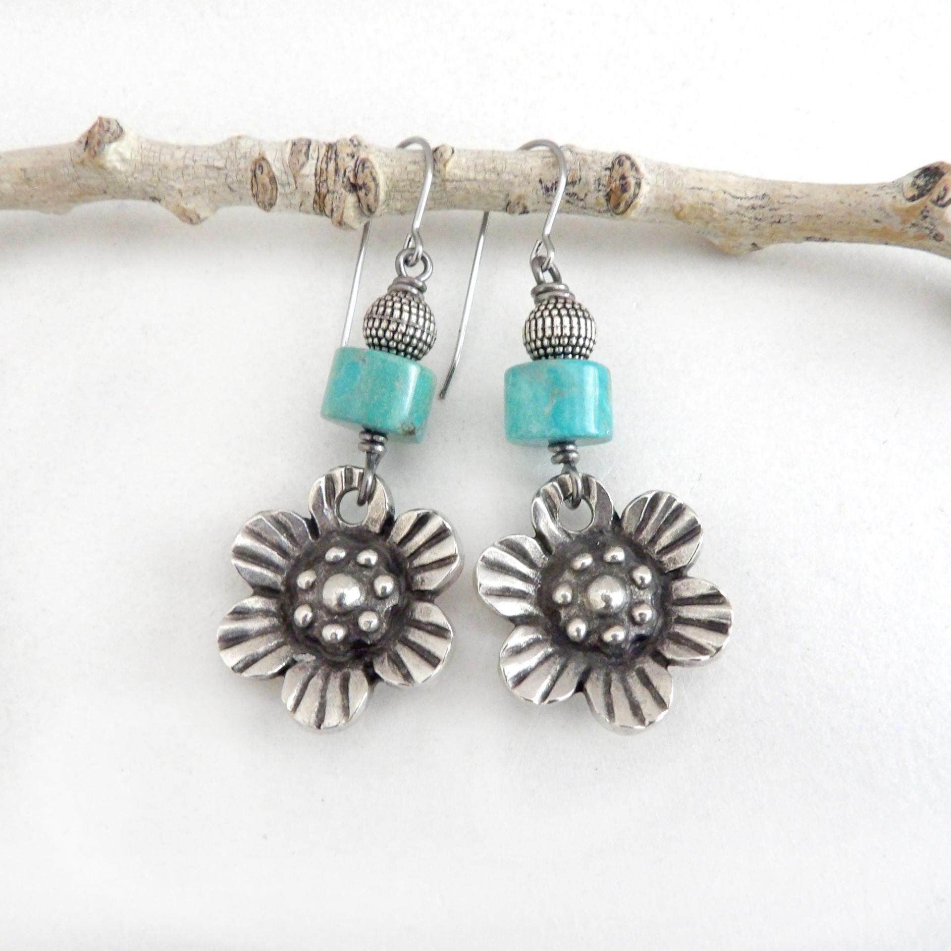 These handcrafted earrings feature silver tone pewter flowers accented with turquoise stones and round textured silver beads. The flowers have a beautiful 3-dimensional design with lots of great intricate detail. They'll make a great gift for a gardener, nature or flower lover.
