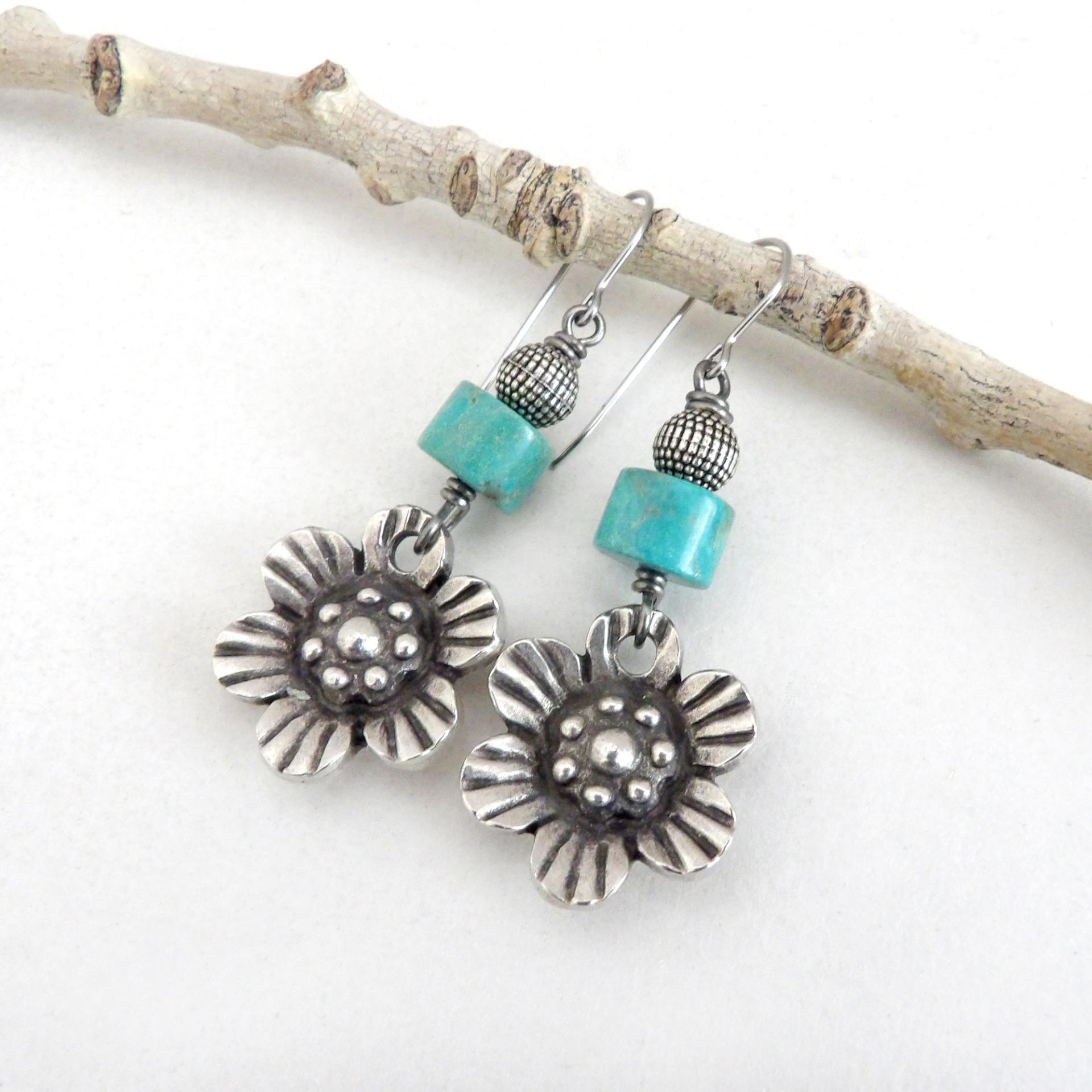 These handcrafted earrings feature silver tone pewter flowers accented with turquoise stones and round textured silver beads. The flowers have a beautiful 3-dimensional design with lots of great intricate detail. They'll make a great gift for a gardener, nature or flower lover.